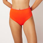 Ikonō La Versatile bikini swimsuit in orange with high-waist bottom. Designed for comfort and support, made from eco-friendly materials. Perfect for all body types, including post-surgery swimwear needs. A stylish and inclusive swimwear choice. #BeWhatMovesYou