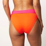 Ikonō La Versatile bikini swimsuit in orange with high-waist bottom. Designed for comfort and support, made from eco-friendly materials. Perfect for all body types, including post-surgery swimwear needs. A stylish and inclusive swimwear choice. #BeWhatMovesYou