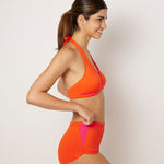 Ikonō's orange Versatile bikini with high-waist shorty bottom and top, designed for comfort, support, and inclusivity. Featuring discreet pockets for prostheses, ideal for women post-mastectomy or after other breast surgeries. Perfect for water sports, Pilates, or lounging, made from sustainable materials with UV50+ protection.