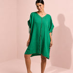 Woman wearing a green dress against a pink background